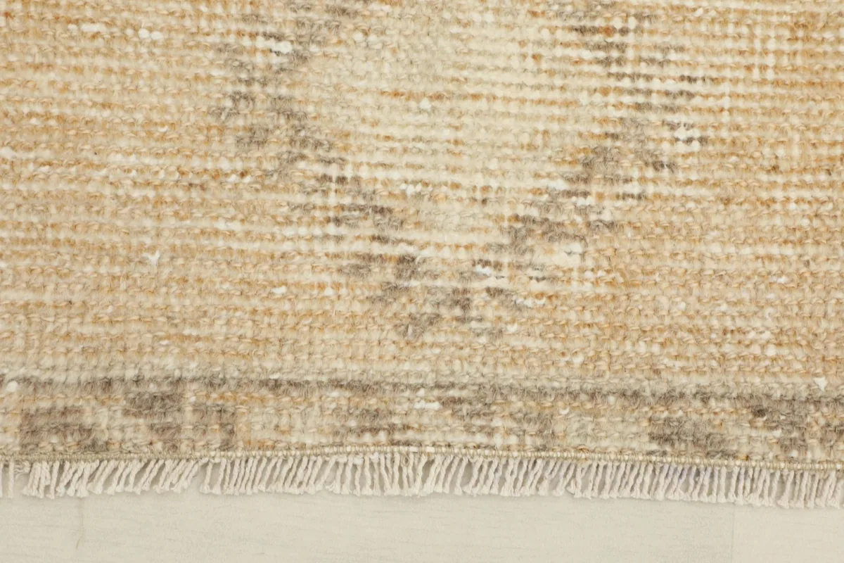 Close-up detail of the rug's low wool pile and visible geometric patterns.