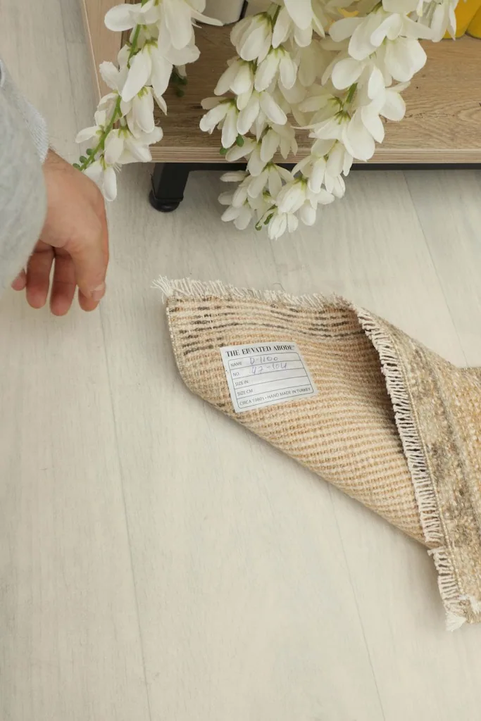 Close-up of the rug's back, showing the hand-knotted cotton foundation and product label.