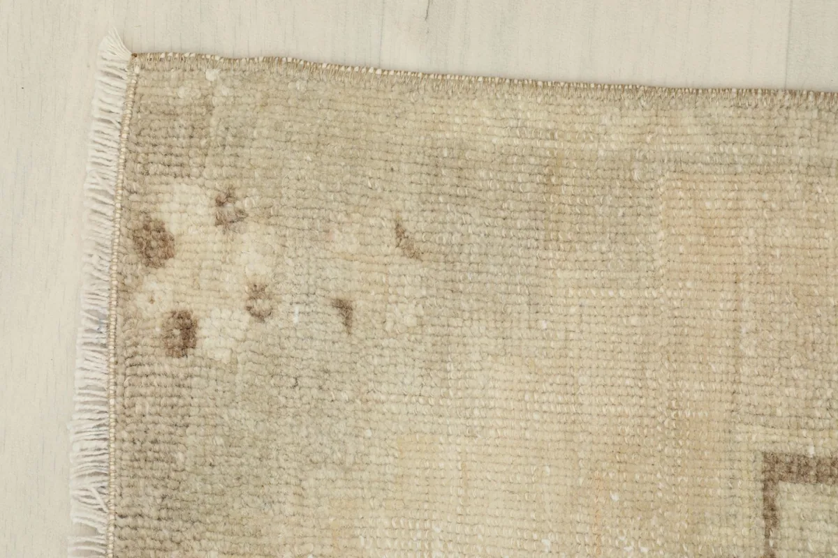 Corner detail showing the subtle color variations and wear on the rug's edge