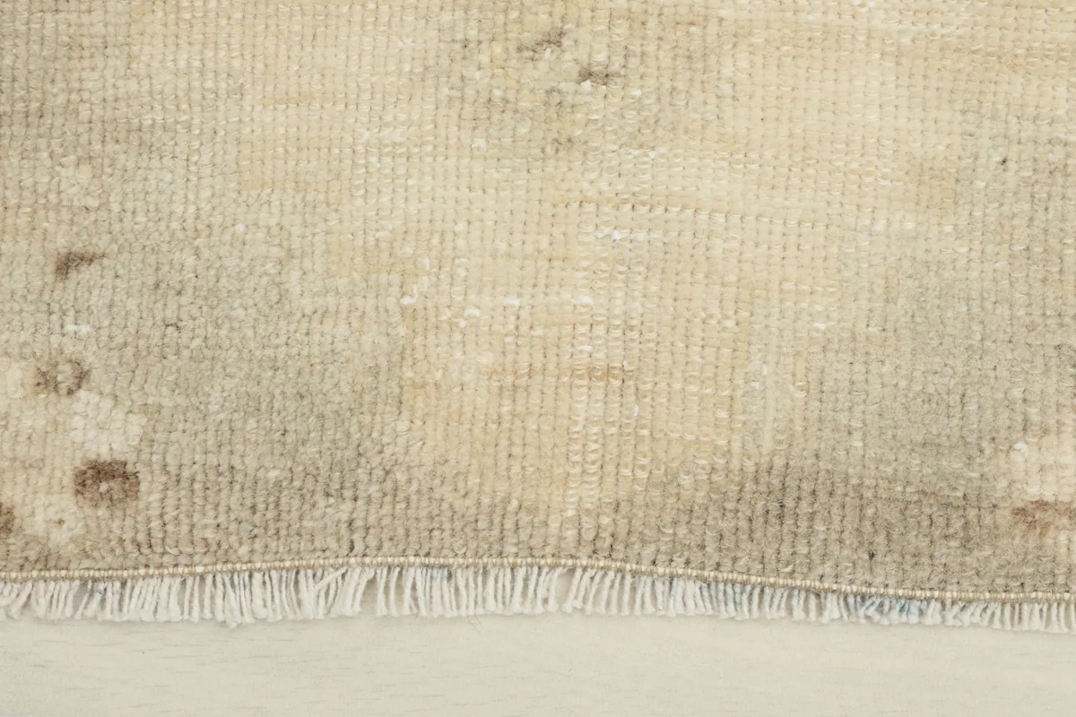 Close-up view of the low wool pile and fringe of the vintage rug