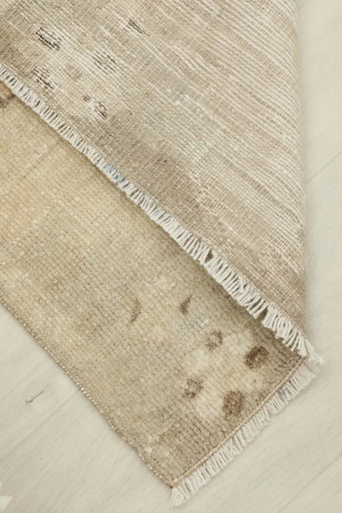 View of the reverse side of the hand-knotted rug, showing the cotton foundation