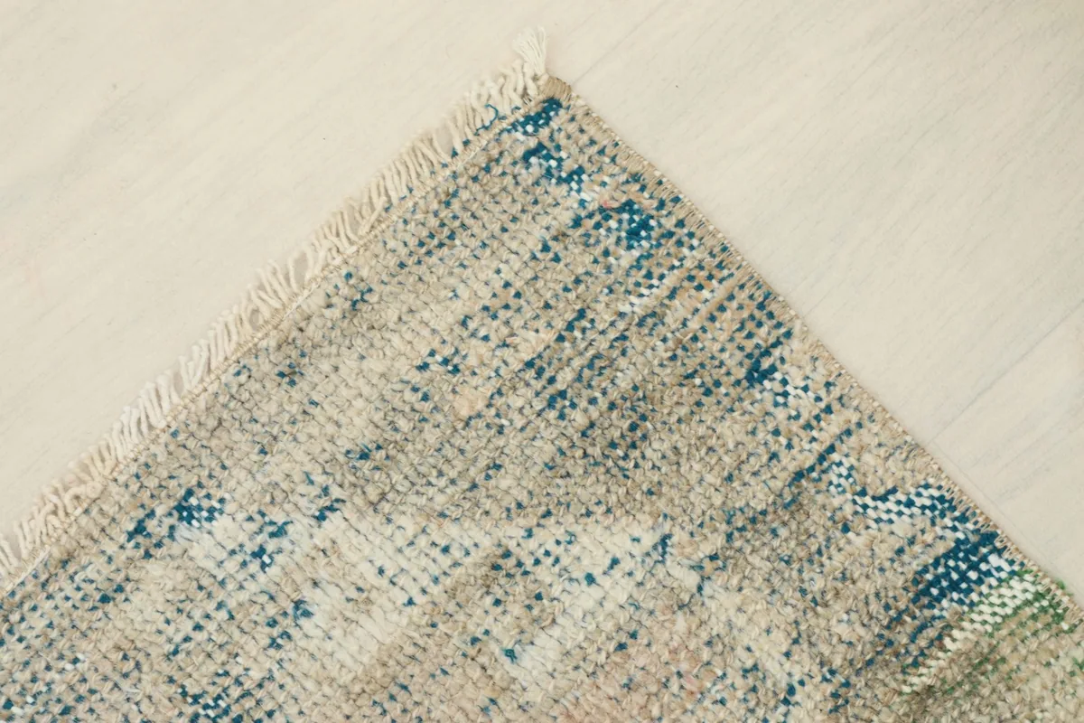 Another corner view highlighting the natural wear and fringe detail of the vintage area rug.