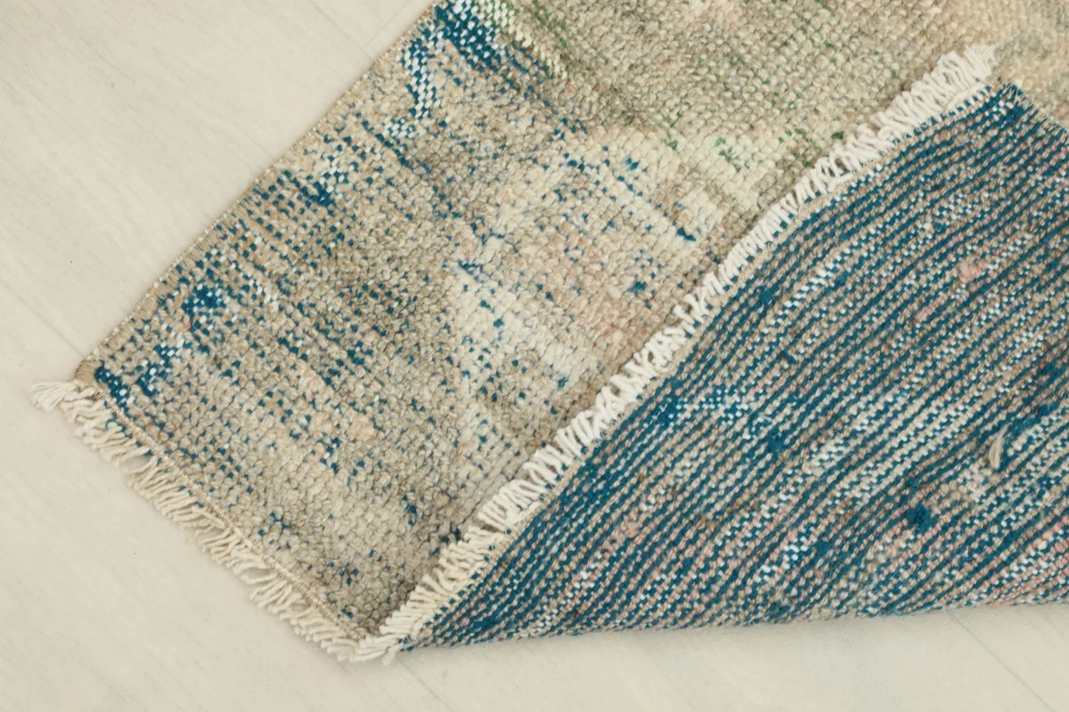 View of the back of the rug, showing the hand-knotted cotton foundation and wool pile.