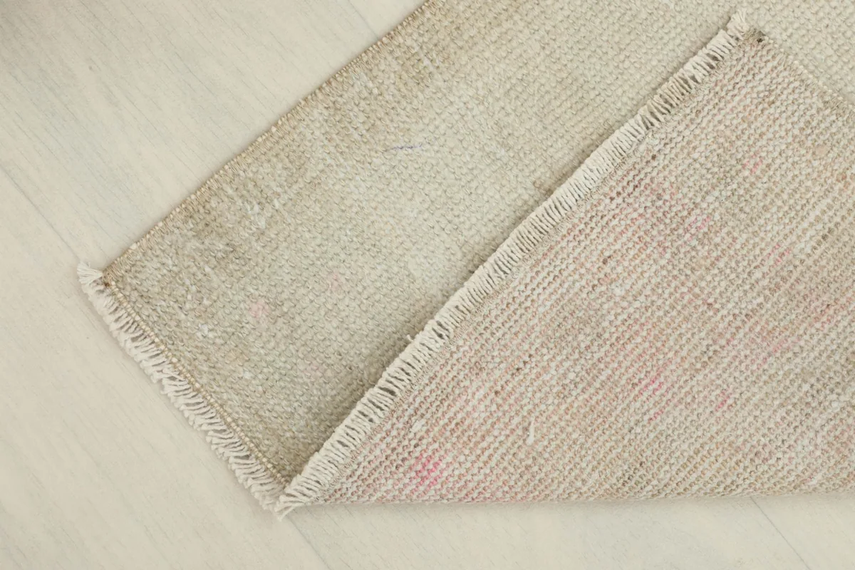 View showing the back of the hand-knotted wool doormat, revealing its cotton foundation.