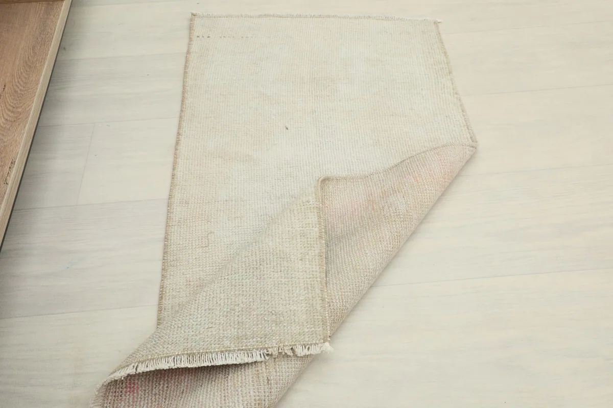The doormat partially folded, showing the front and back textures on a light floor.