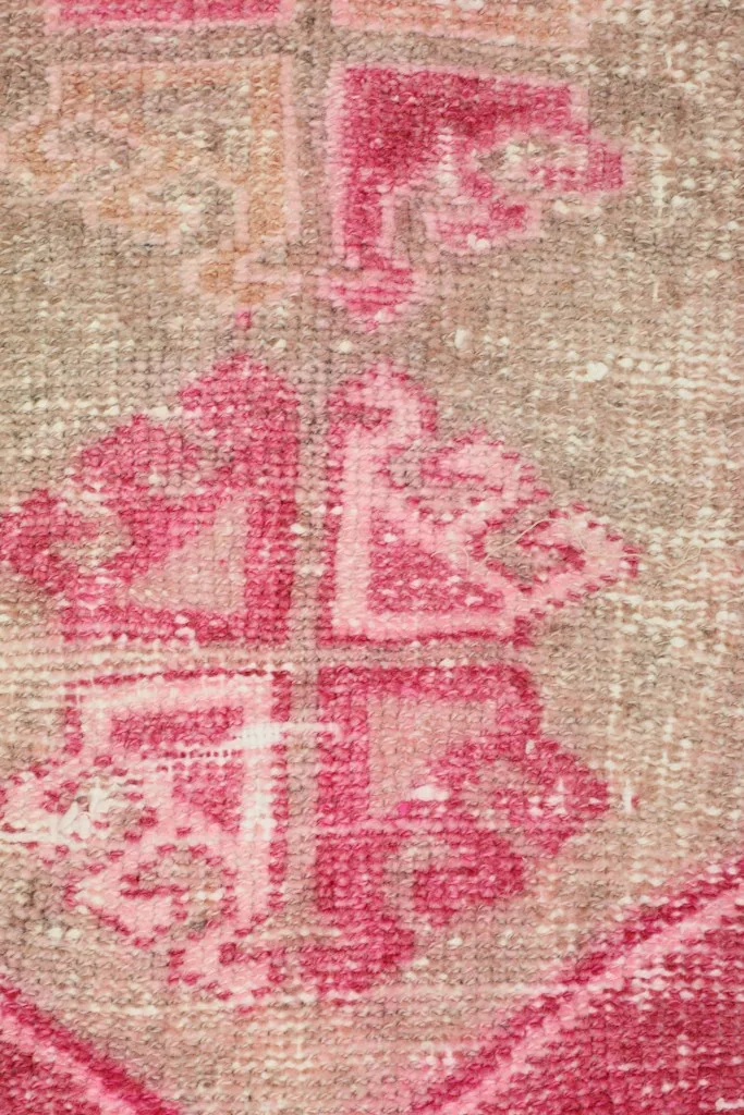 Detailed view of the tribal geometric motifs in the beige center of the rug