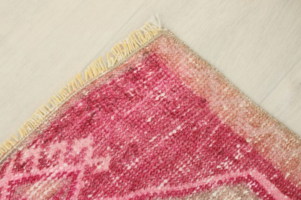 Corner view showing the faded rose border and natural fringe