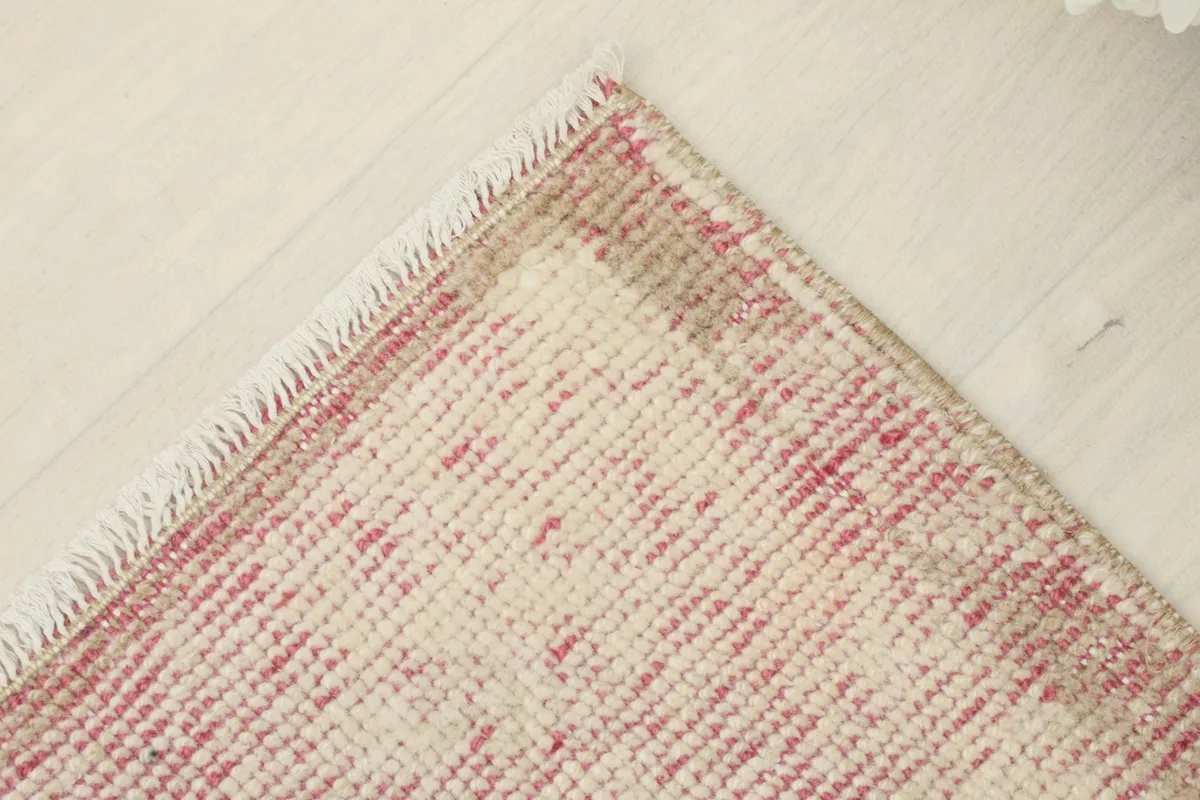 Overhead angled view of one corner of the rug, displaying the low pile and vintage character.