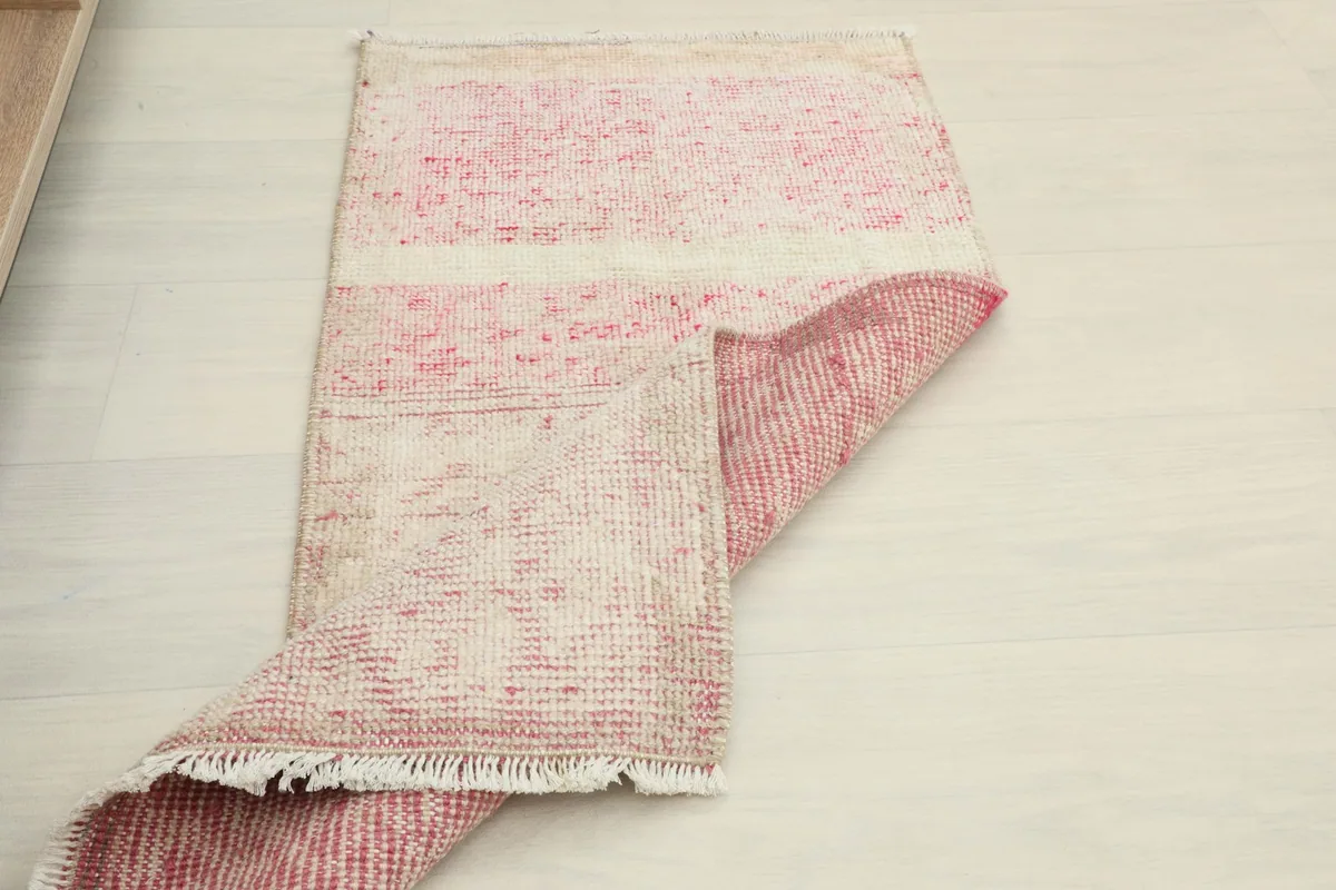 The rug partially folded, showing the flexibility and construction of the vintage Anatolian piece.