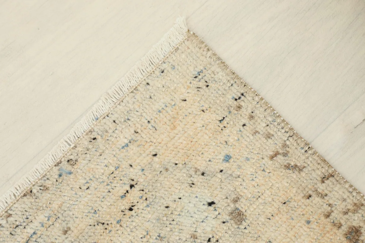 Another close-up of a rug corner, highlighting the natural wear and fringe detail