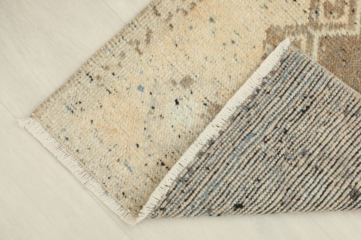 View of the rug folded to show the wool pile on the cotton foundation