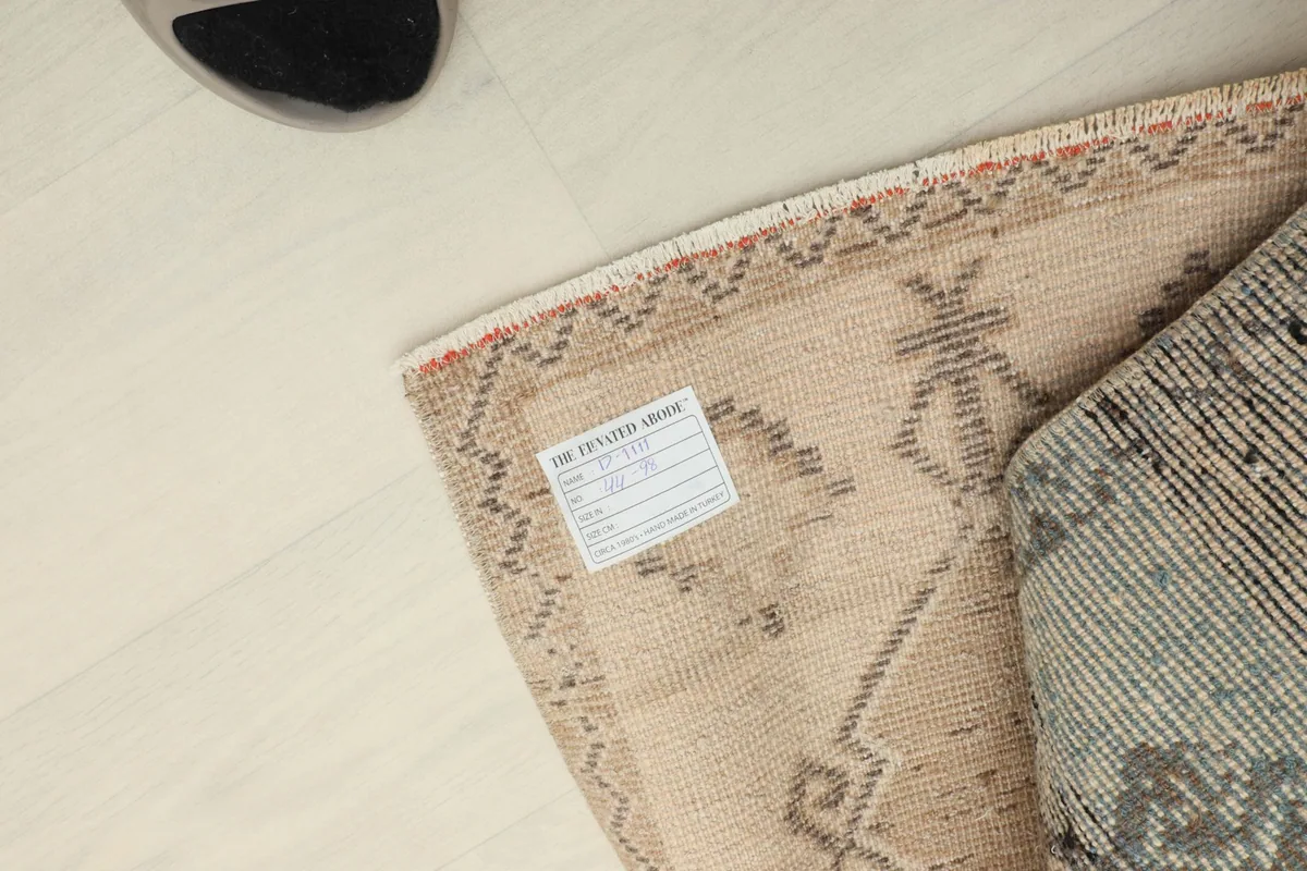 Close-up of the rug's back with a product tag attached, showing construction details