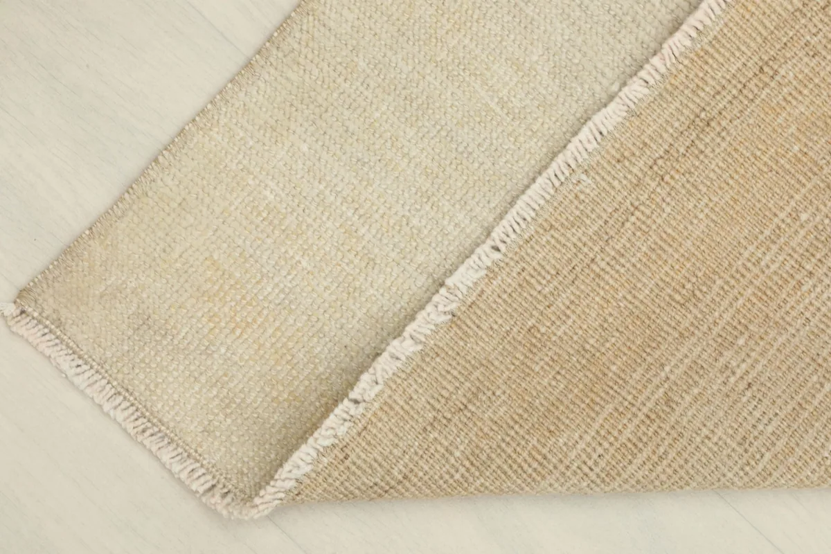 View of the reverse side of the rug, showing the cotton foundation