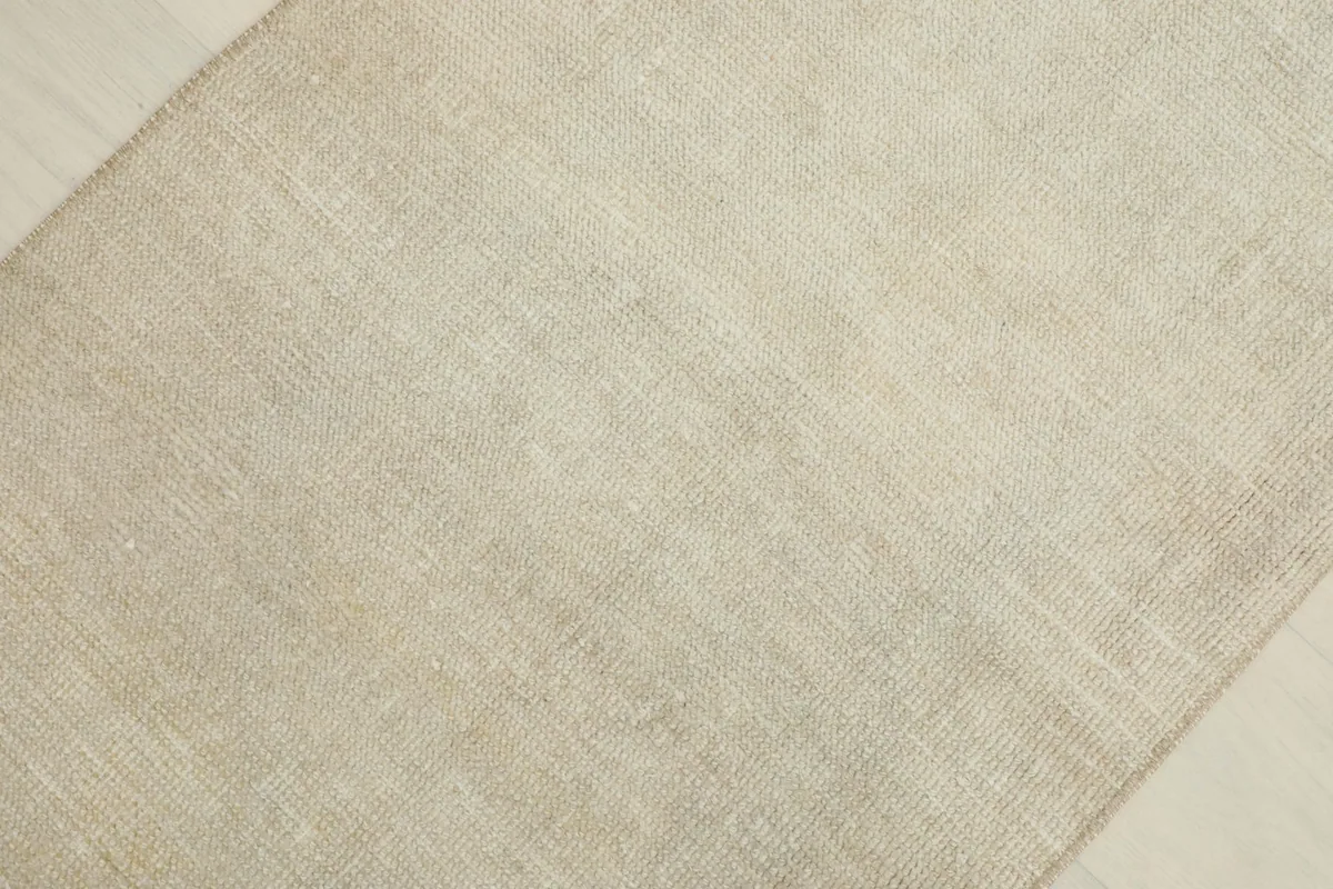Overhead view of a section of the cream rug, emphasizing its uniform color