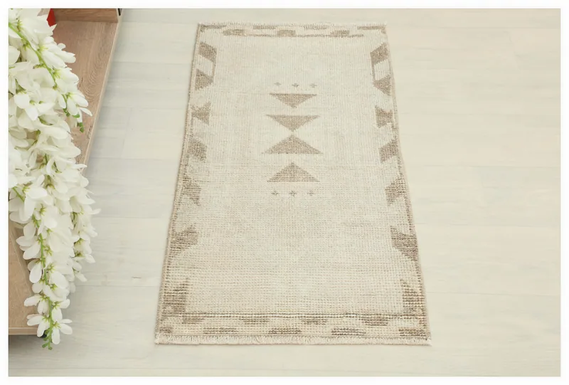 Full top view of the ivory and tan geometric vintage Anatolian wool rug on a white background.