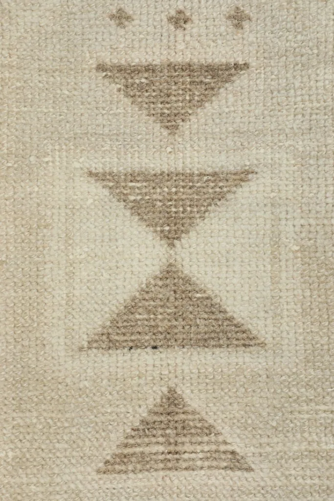 Detailed view of the stacked tan triangle pattern in the center of the vintage Anatolian rug.