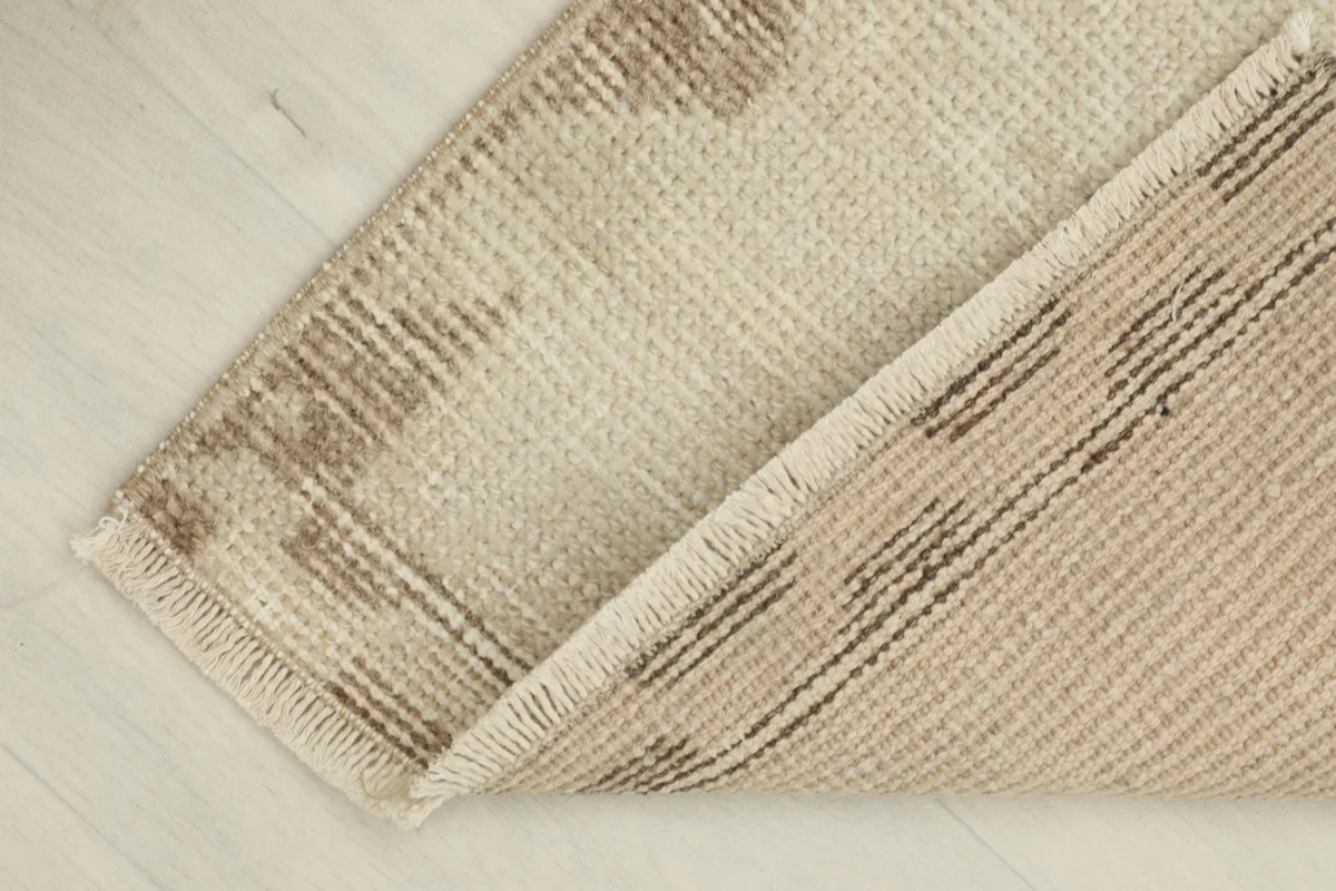 Partial view of the back of the hand-knotted rug, revealing the cotton foundation and construction.