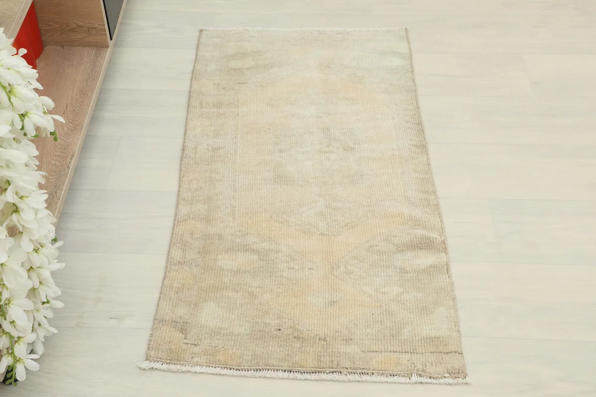 Overhead view of the 1'8" x 3'3" beige vintage Anatolian rug with subtle geometric patterns