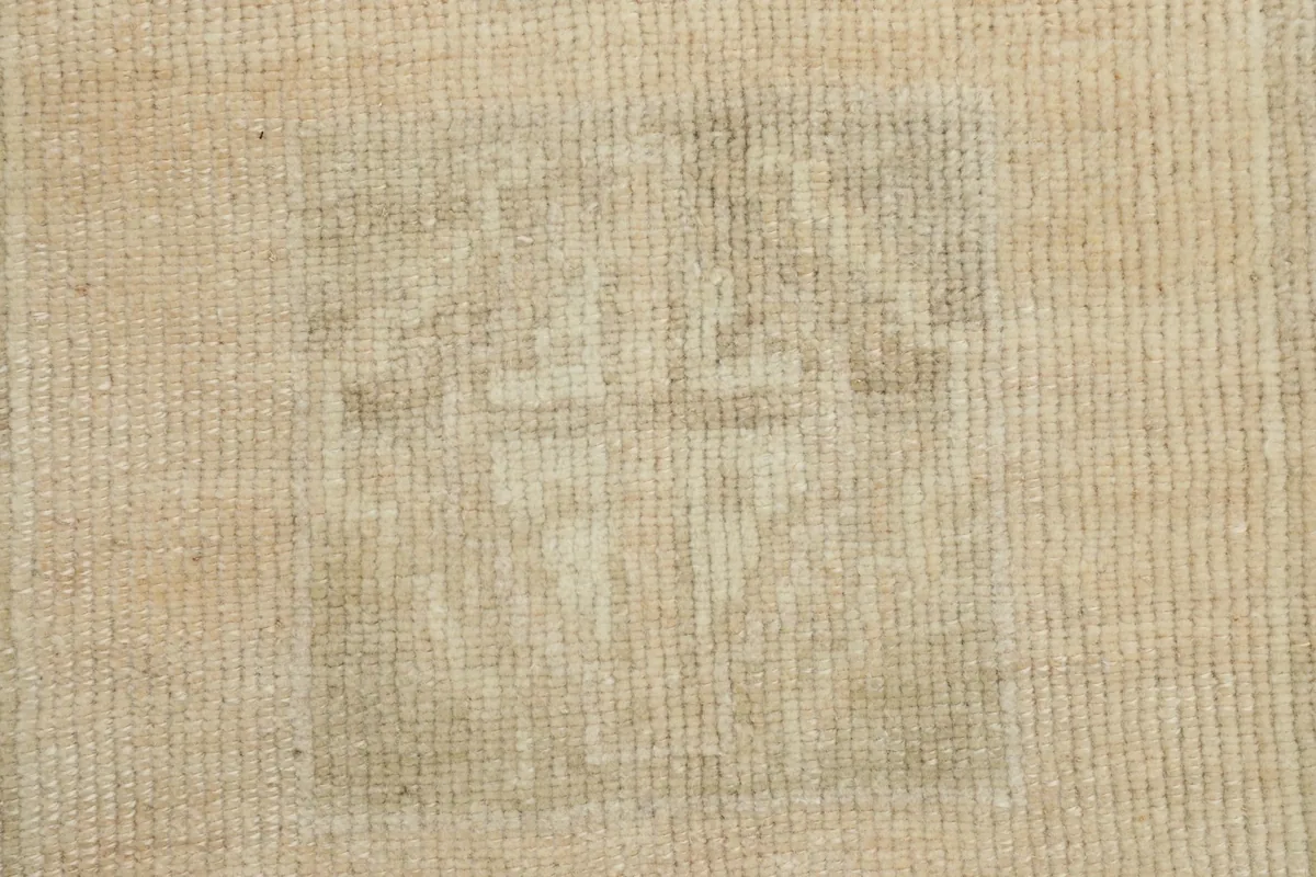 Detailed view of the low pile and textured surface, highlighting the worn-in character of the rug