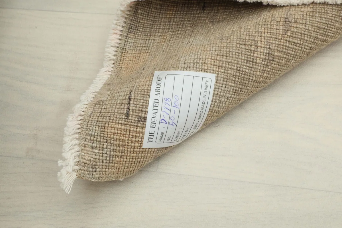 Reverse side of the rug, showing the cotton foundation and a product label on the underside
