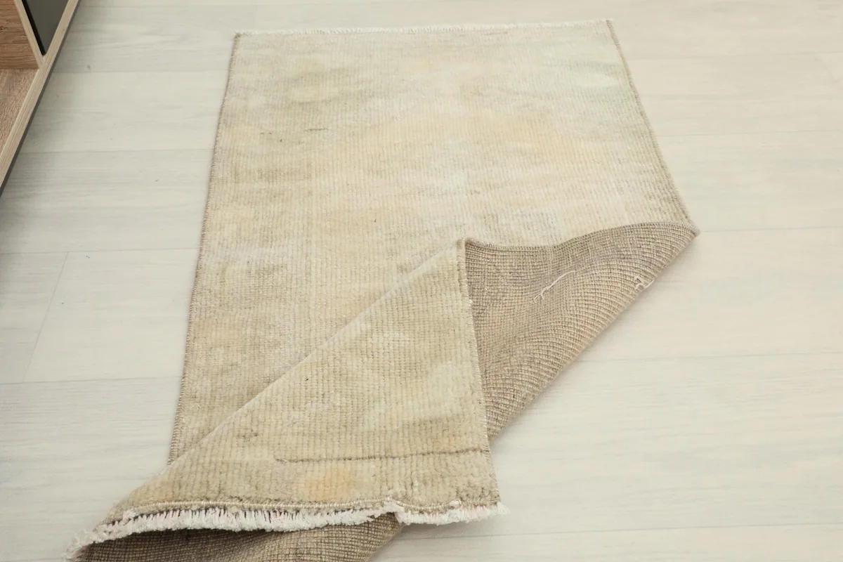 Rug partially folded, displaying the reverse side of the hand-knotted construction
