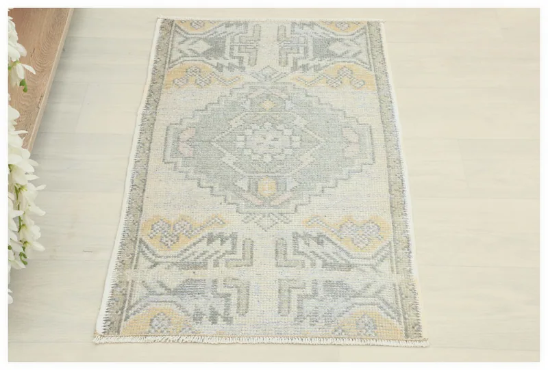 Full top view of the 1'8" x 3'2" ivory and gray geometric vintage Anatolian doormat.