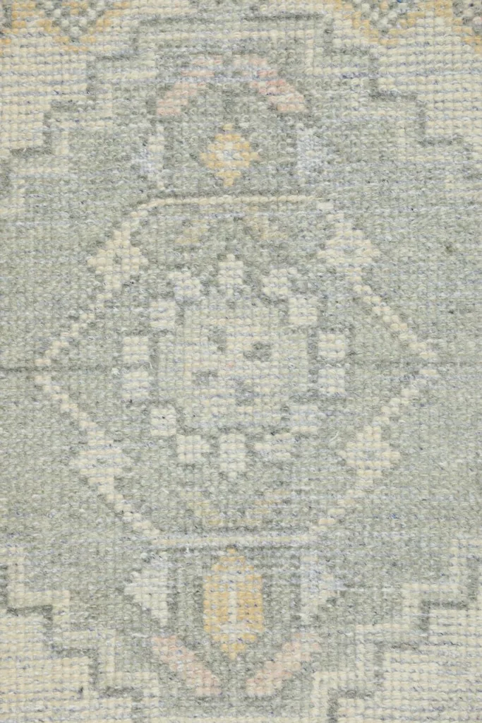 Detailed view of the central gray medallion with subtle pink and yellow accents in the design.