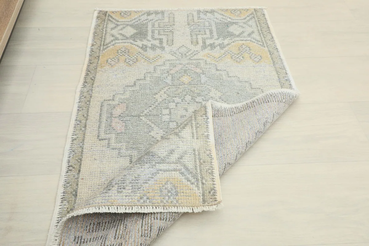 Angled view with a section of the rug folded back, highlighting the overall design and texture.