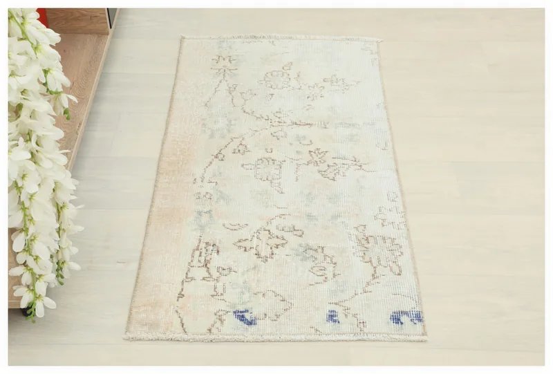 Full top view of the 2x3 ivory vintage Anatolian rug with floral patterns on a white background