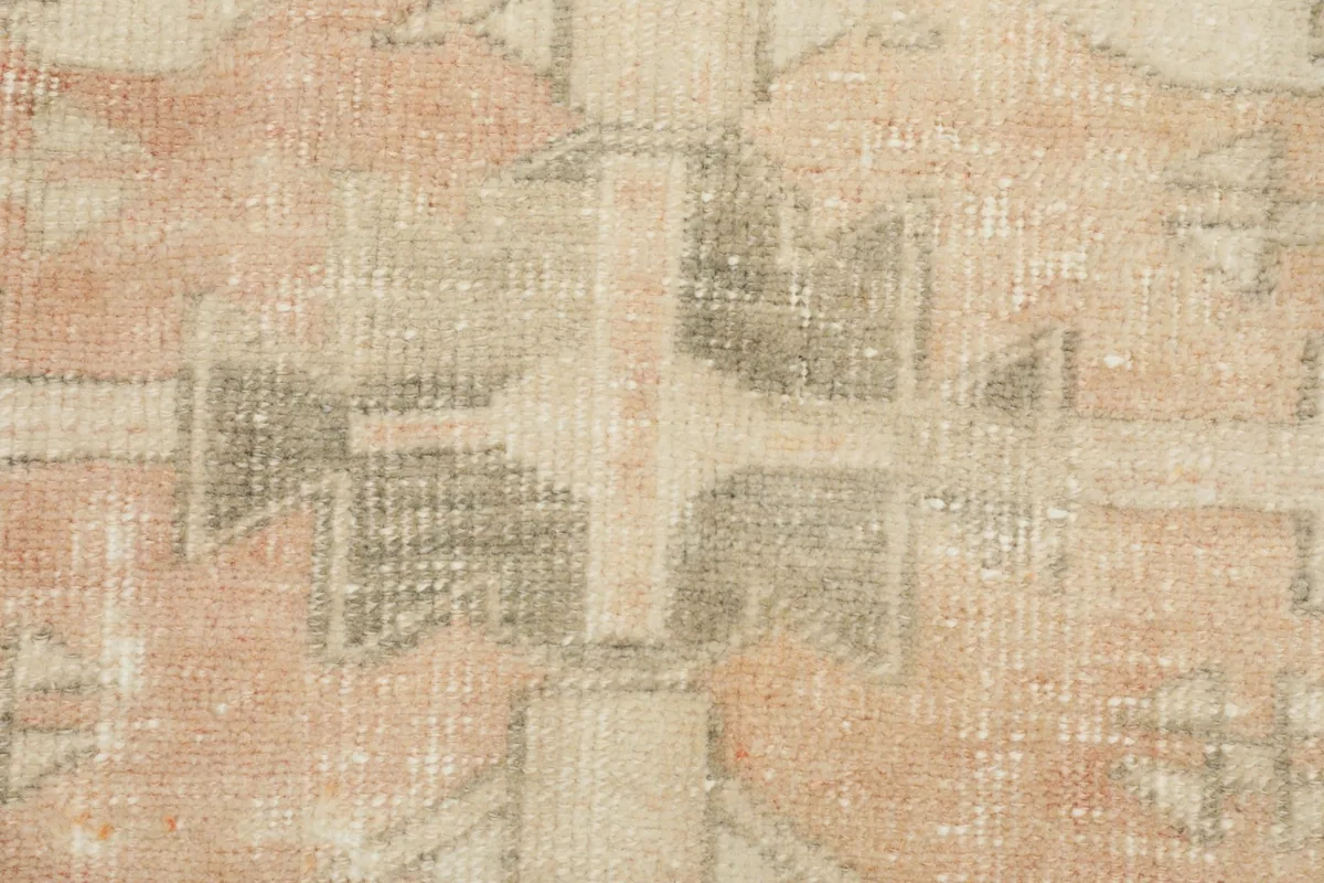 Tight detail of the central geometric design, showing faded rust and charcoal elements
