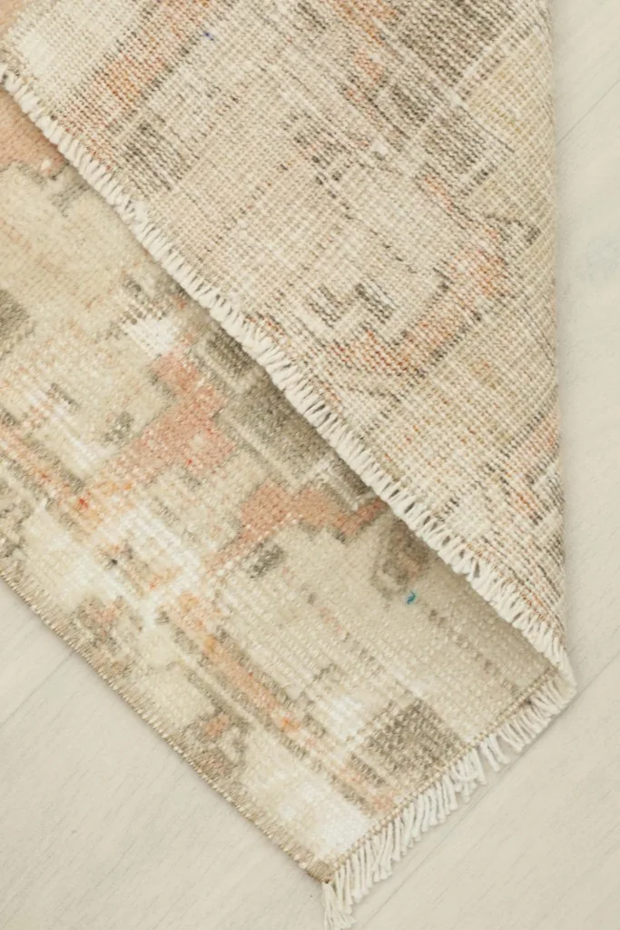 Doormat folded to show the thickness of the wool pile and the cotton foundation