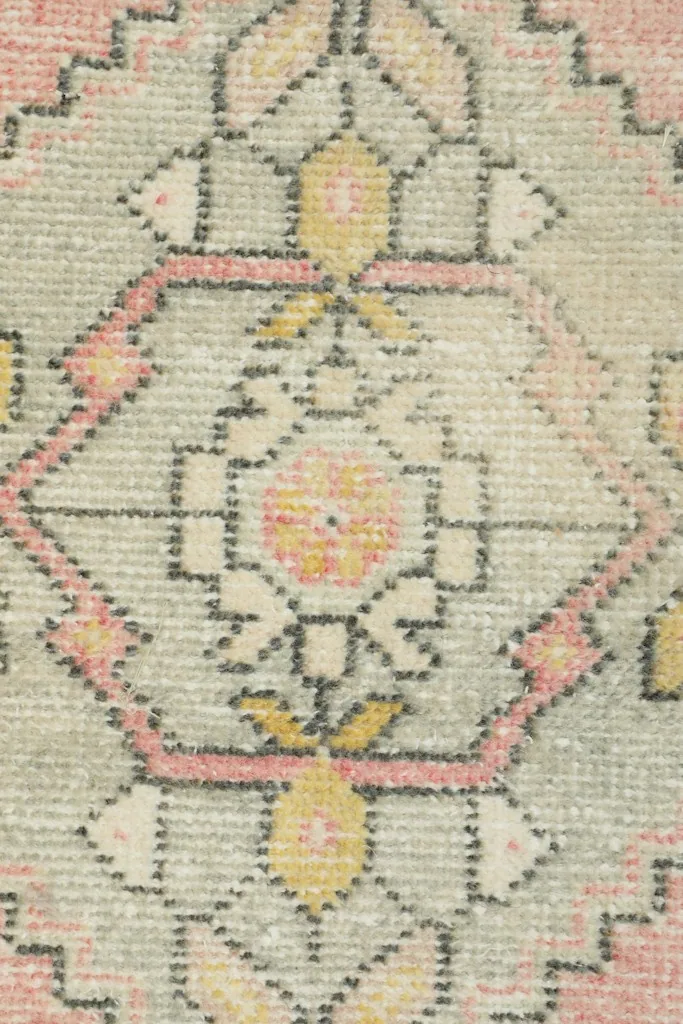 Detailed view of the intricate geometric patterns and color variations in the rug's center