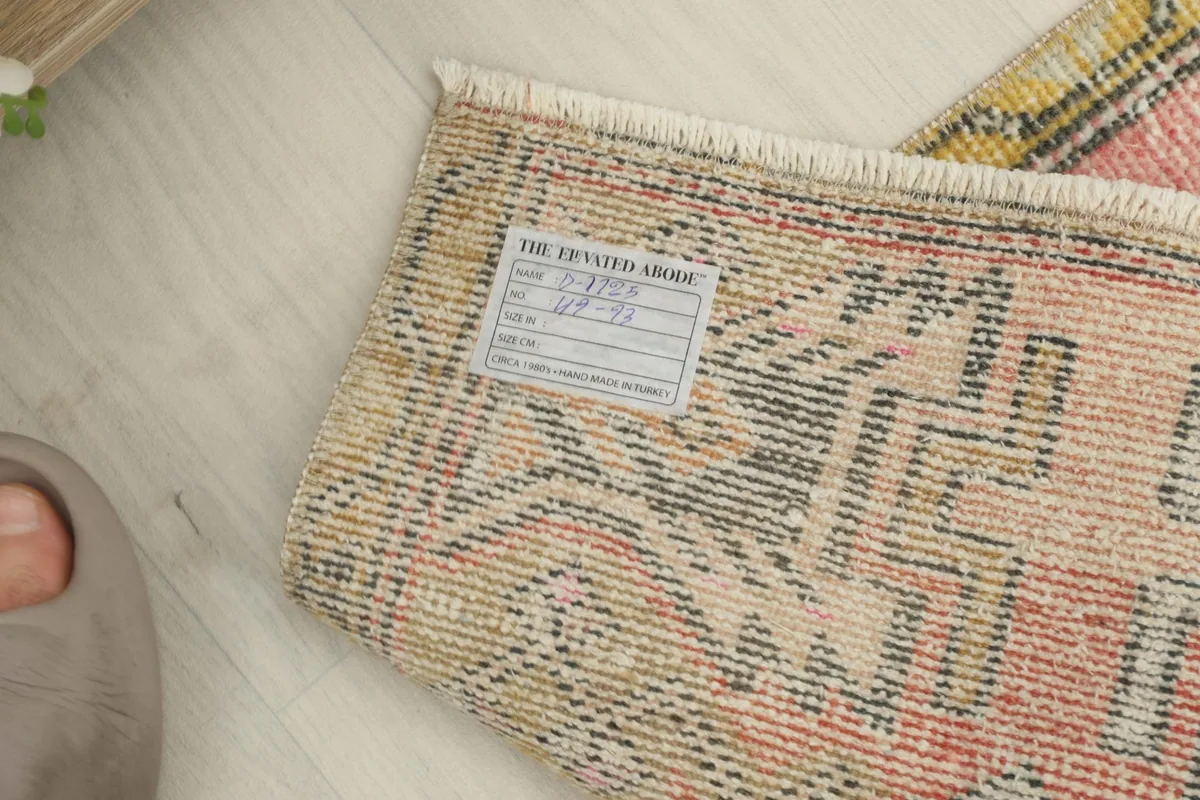 View of the back of the rug, showing the hand-knotted construction and care label