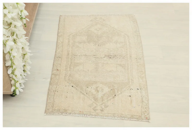 Full top view of the 1'9" x 2'8" ivory and beige geometric vintage Anatolian rug on a white background.