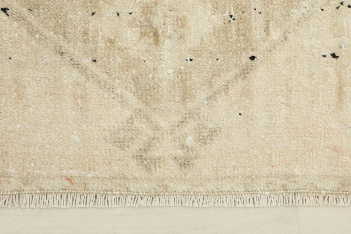 Close-up detail of the hand-knotted wool pile and fringe, showing the subtle color variations and wear.