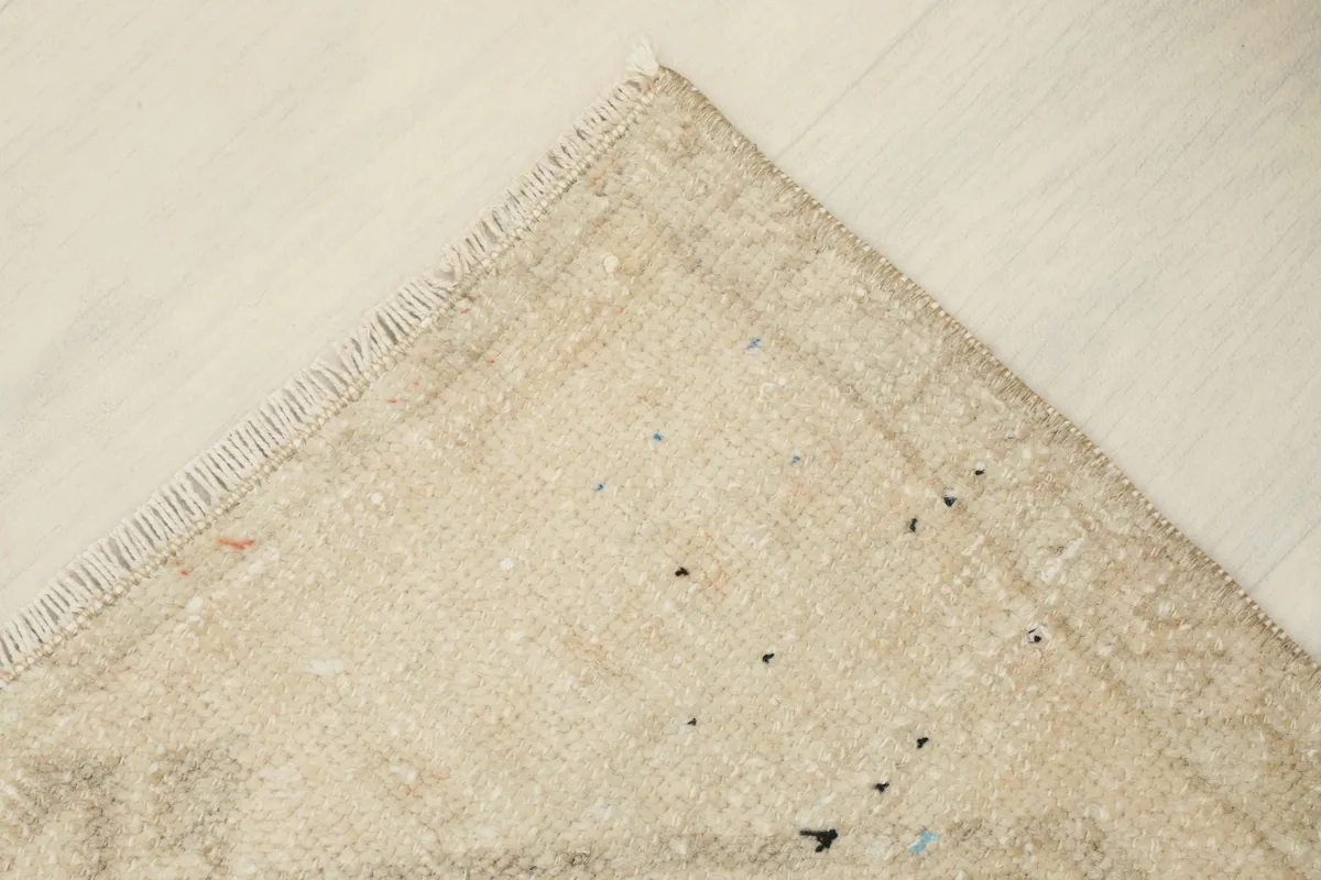 Corner view of the rug, showing the integrity of the border and fringe, and gentle signs of age.
