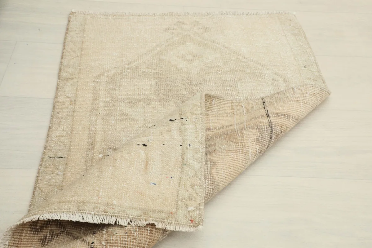 The rug partially folded, illustrating its flexibility and the thickness of the hand-knotted wool on cotton.