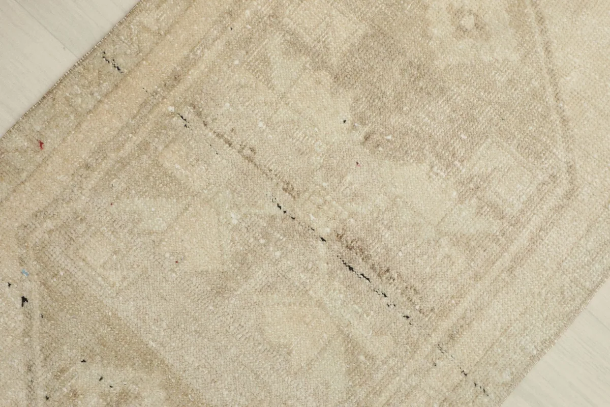 Overhead view focusing on the central geometric motif and faded details of the vintage rug.