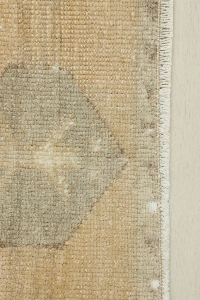 Close-up of the lower gray geometric detail and the short fringe along the edge.