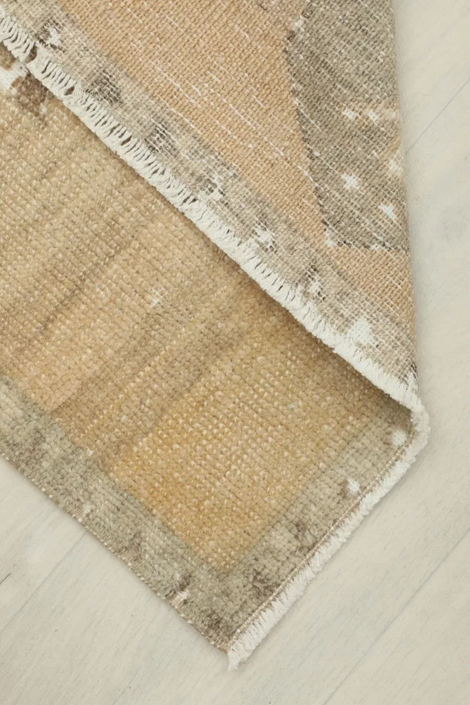 View of the rug's back, revealing the hand-knotted cotton foundation and wool pile.