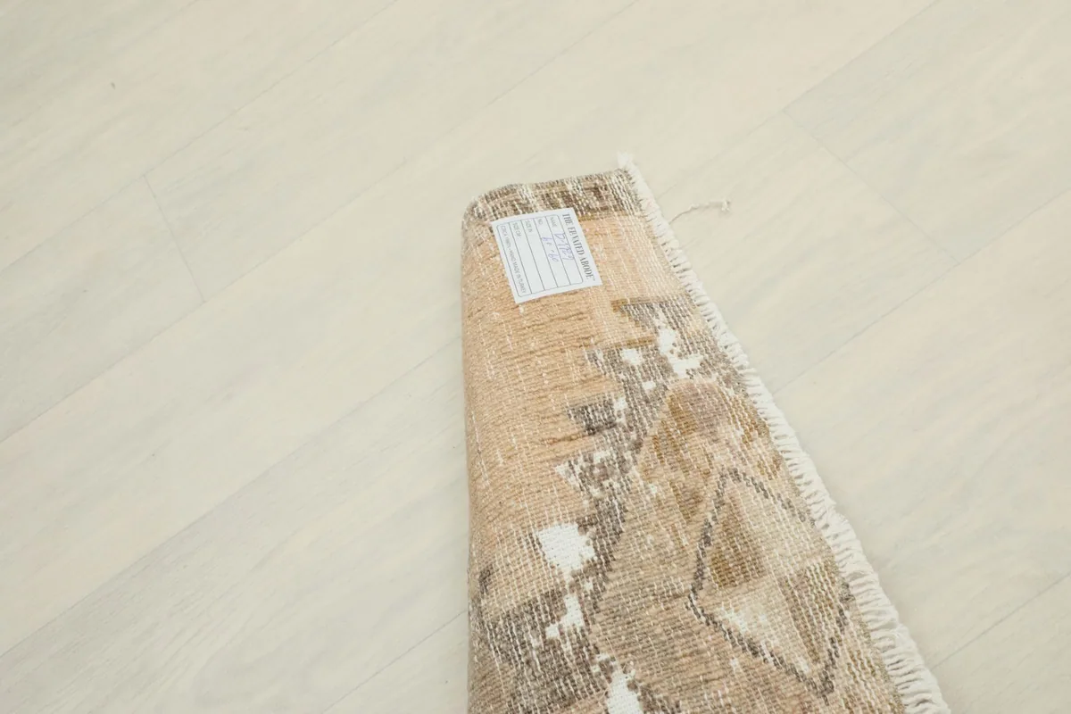 The rug rolled up, showing its compact size and the tag on the underside.