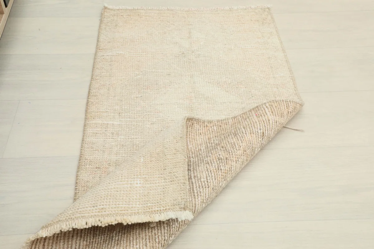 Partial view of the rug's back, revealing the intricate hand-knotted cotton foundation.