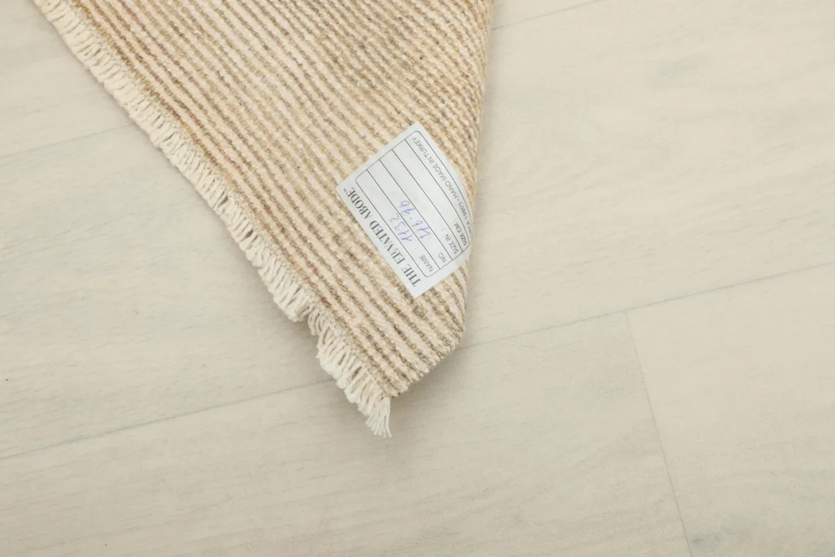 Close-up of the rug's back with a product label, showing details of its origin and size.