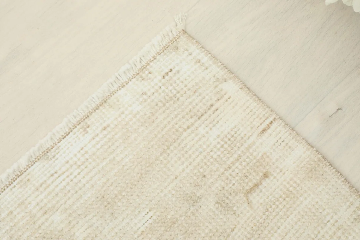 Corner detail of the vintage doormat, showing the tightly woven texture and slight variations in color.