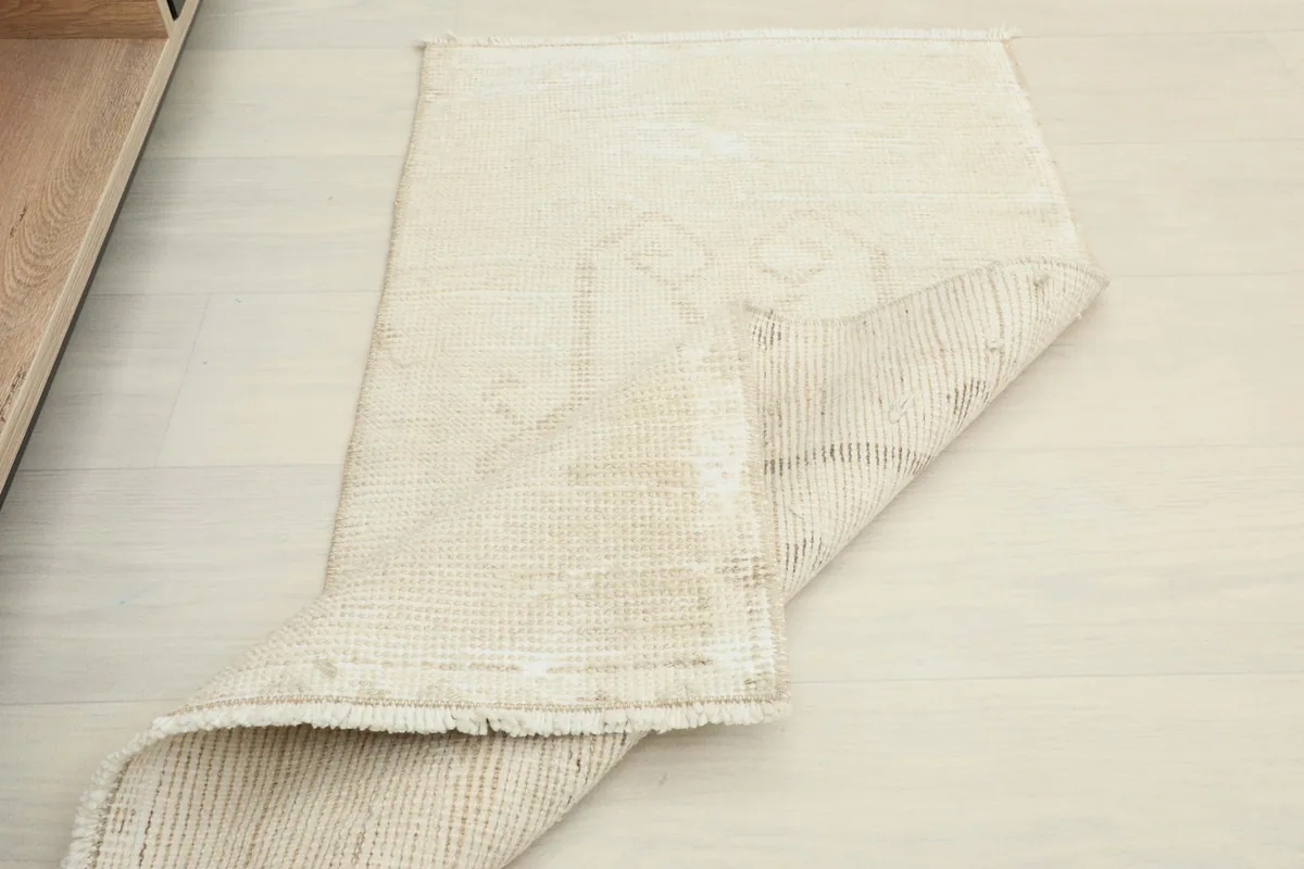 The rug partially folded to show the flexibility and thickness of the vintage wool construction.