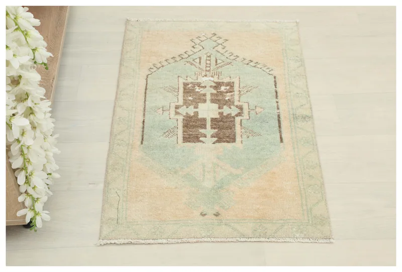 Full top view of the beige and green vintage Anatolian area rug on a white background.