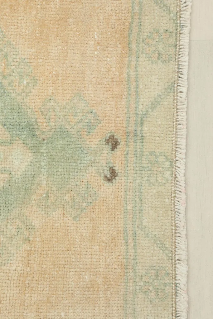 Close-up of the rug's surface, showing minor spots and the texture of the wool pile.