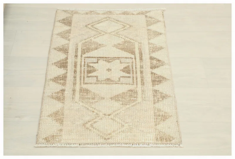 Full top view of the 1'7" x 2'5" cream and brown geometric vintage Anatolian doormat on a white background.