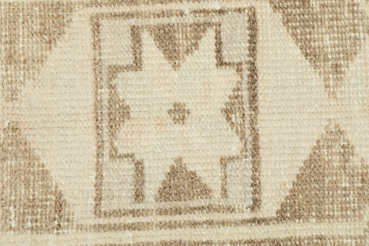 Extreme close-up of the central star-like geometric design, revealing the individual knots and wool texture.