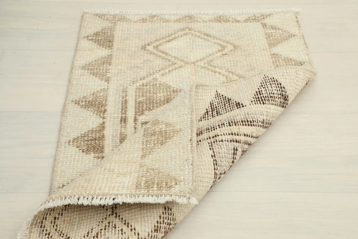 Partial view of the rug's back, showing the craftsmanship of the hand-knotted wool on cotton foundation.